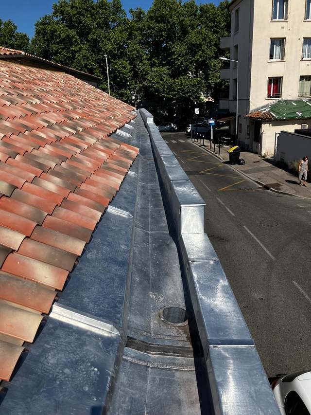 Chéneau et solins en zinc en rive d'une toiture en tuiles
