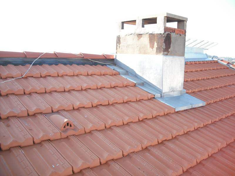 Couverture en tuiles neuves avec solins zinc autour d'un conduit de cheminée