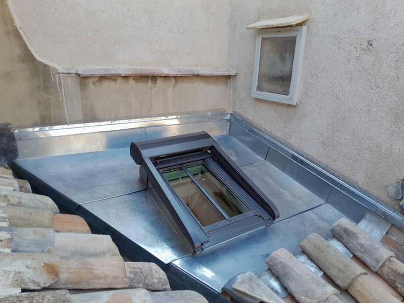 Fenêtre de toit entourée de solins en zinc