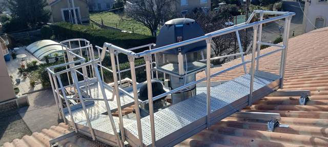 Passerelle en aluminium avec garde-corps posée sur une toiture en tuiles autour d'un extracteur