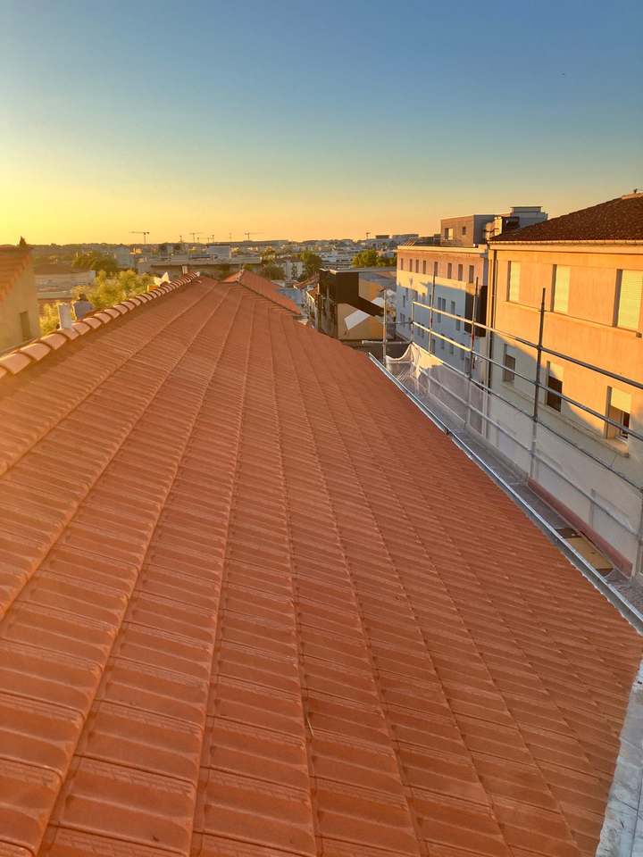 Toiture en tuiles neuves au coucher du soleil, avec échafaudage en rive